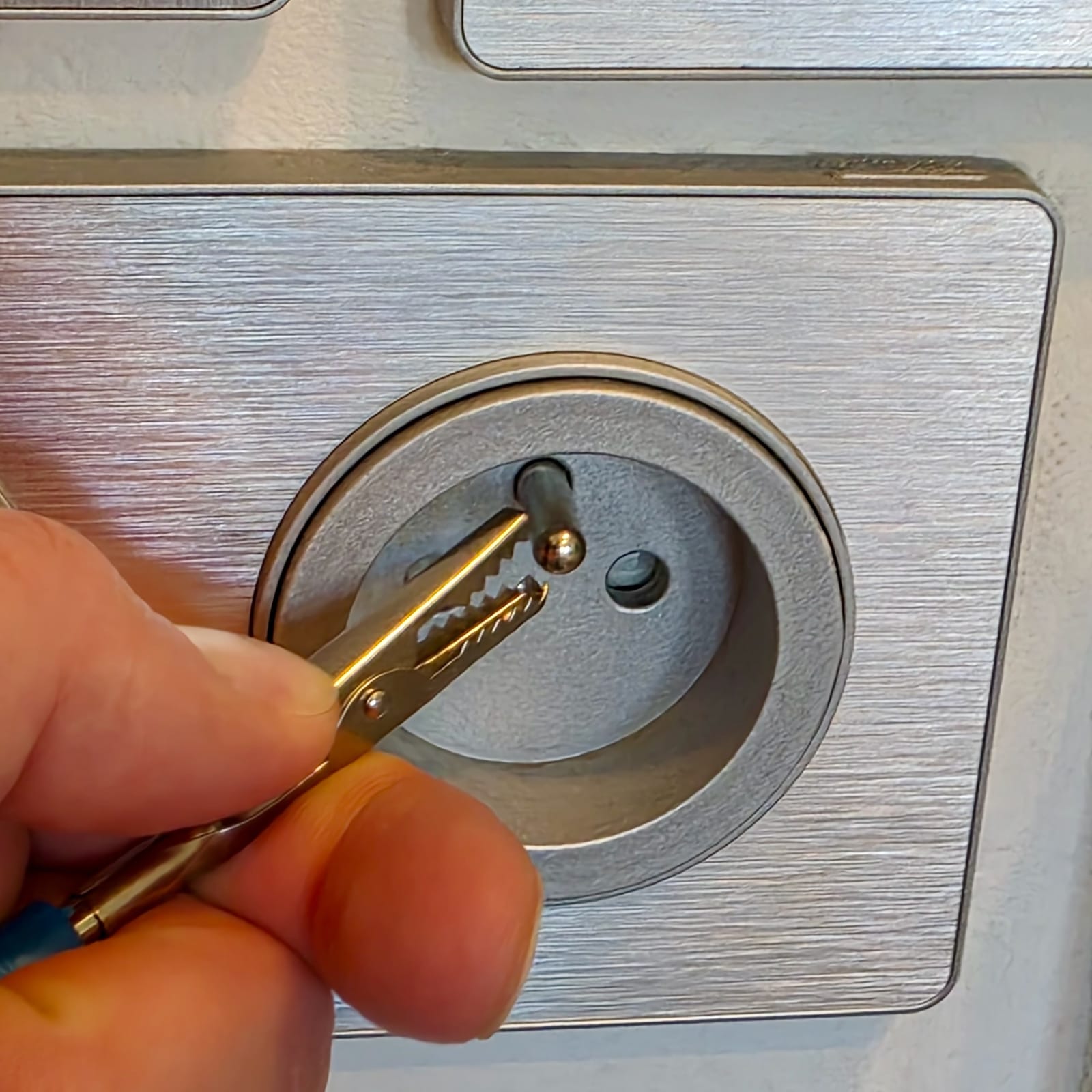 Ouverture de la borne de terre d'une prise Schneider pour brancher un bracelet antistatique