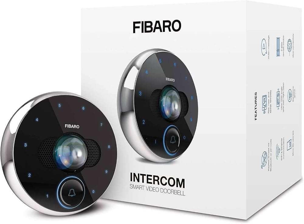 Sonnette vidéo intelligente ronde Fibaro Intercom noire et argentée posée devant sa boîte d’emballage blanche.