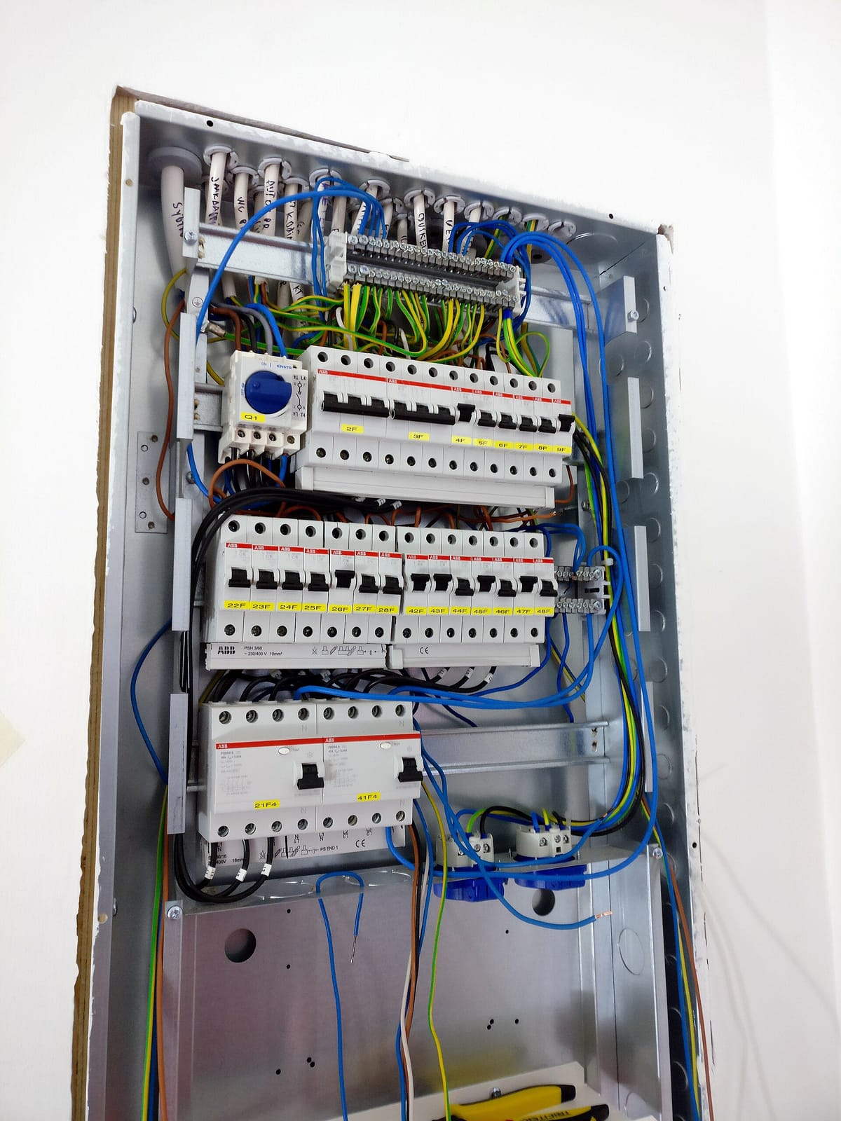 Tableau électrique ouvert avec protections, conducteurs et repérage