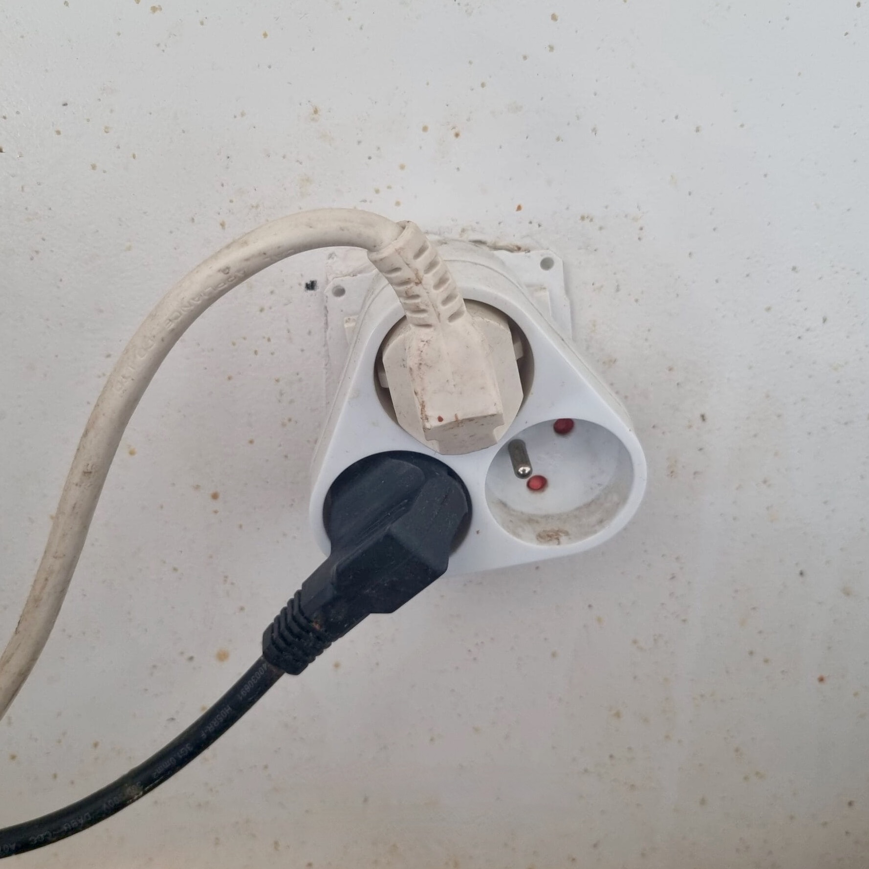 Multiprise surchargée branchée dans une prise murale, risque incendie