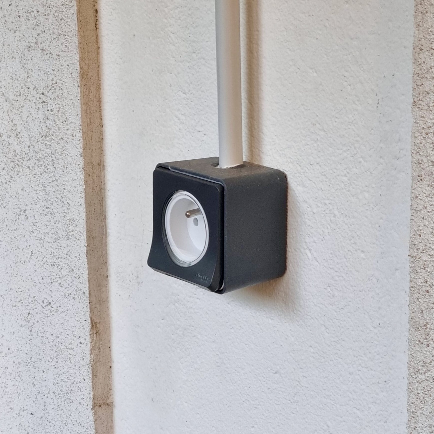 Prise Schneider Mureva Styl sur mur blanc extérieur