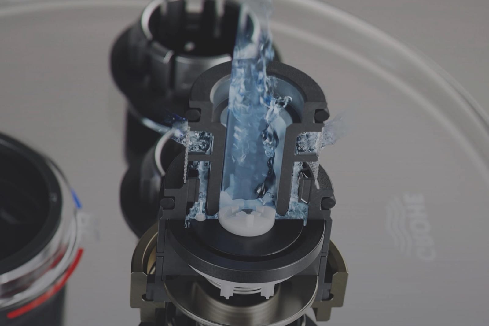 Gros plan du mécanisme d'un mitigeur Grohe avec un filet d'eau