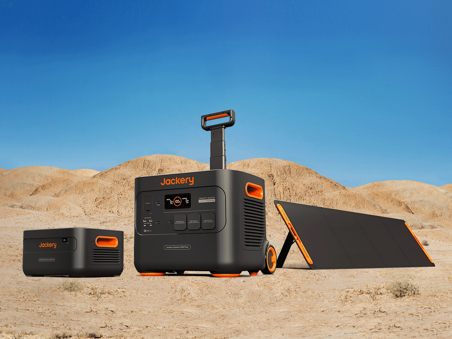 Une station électrique Jackery Explorer 2000 Plus sur roulettes avec poignée télescopique, accompagnée d’une batterie additionnelle et d’un panneau solaire dans un paysage désertique.