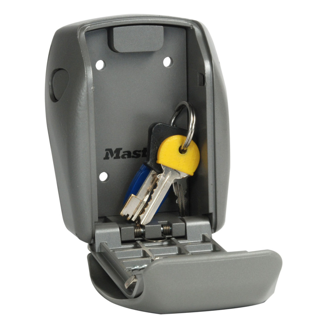 Intérieur d’un coffre à clés gris Master Lock ouvert contenant un trousseau de clés avec un porte-clés jaune.