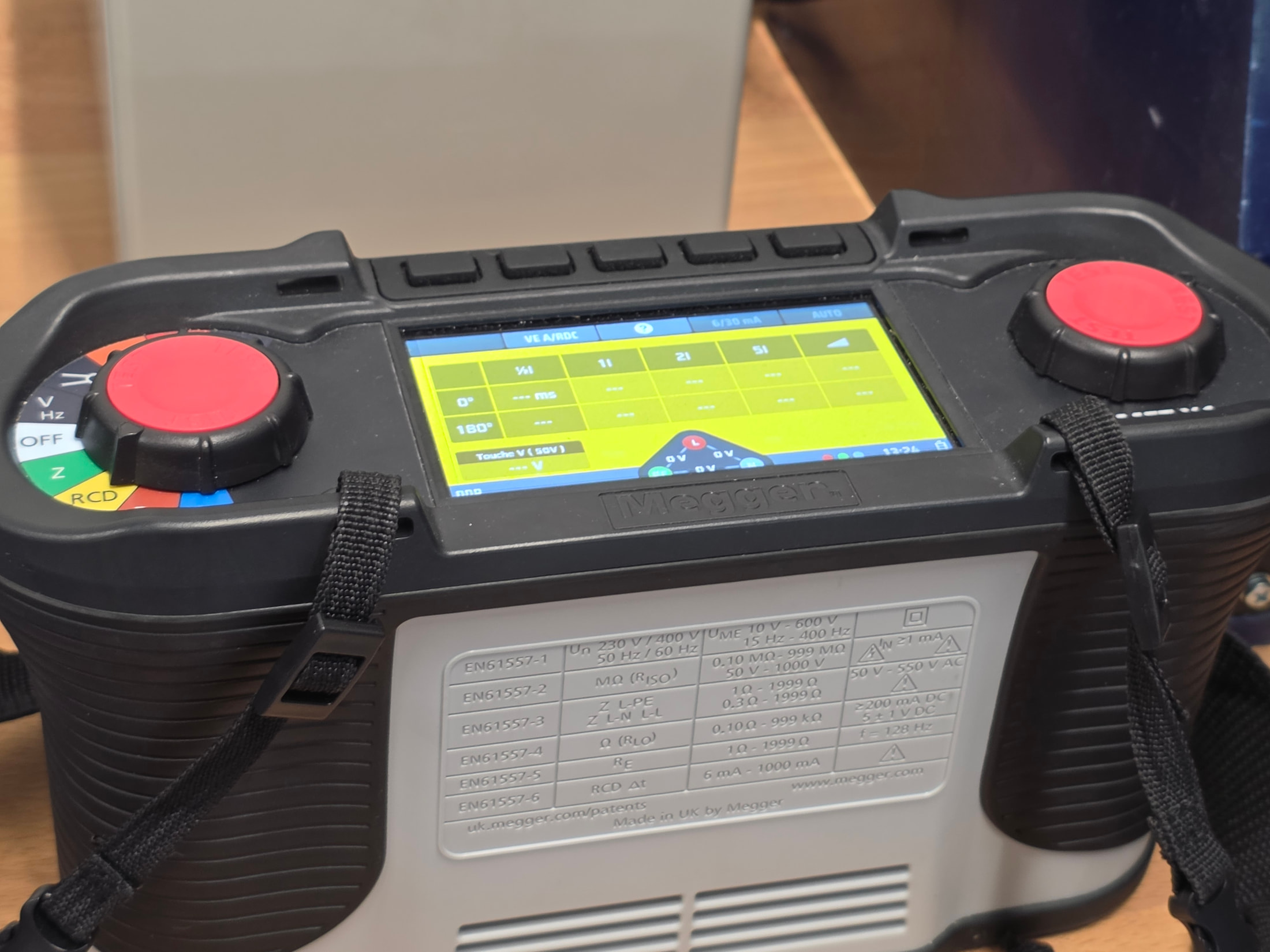 Appareil de mesure à deux commandes rouges et écran jaune, vu au showroom Megger
