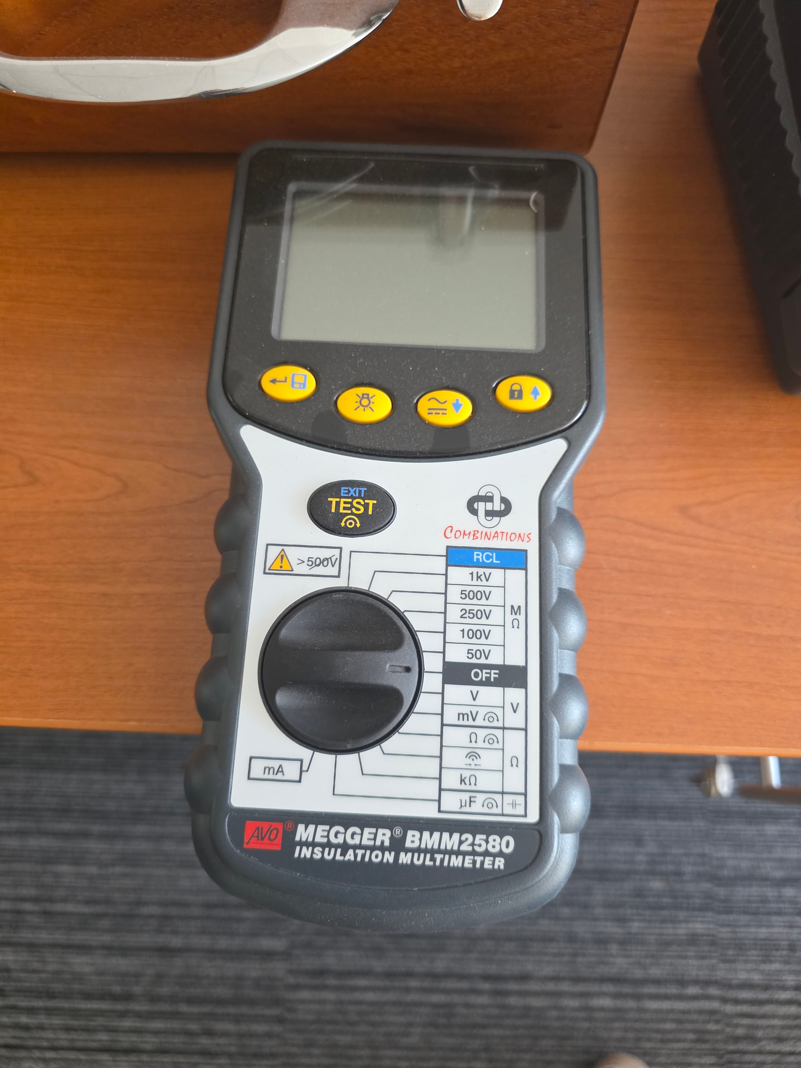 Instrument portable de mesure exposé chez Megger, avec boutons jaunes et écran