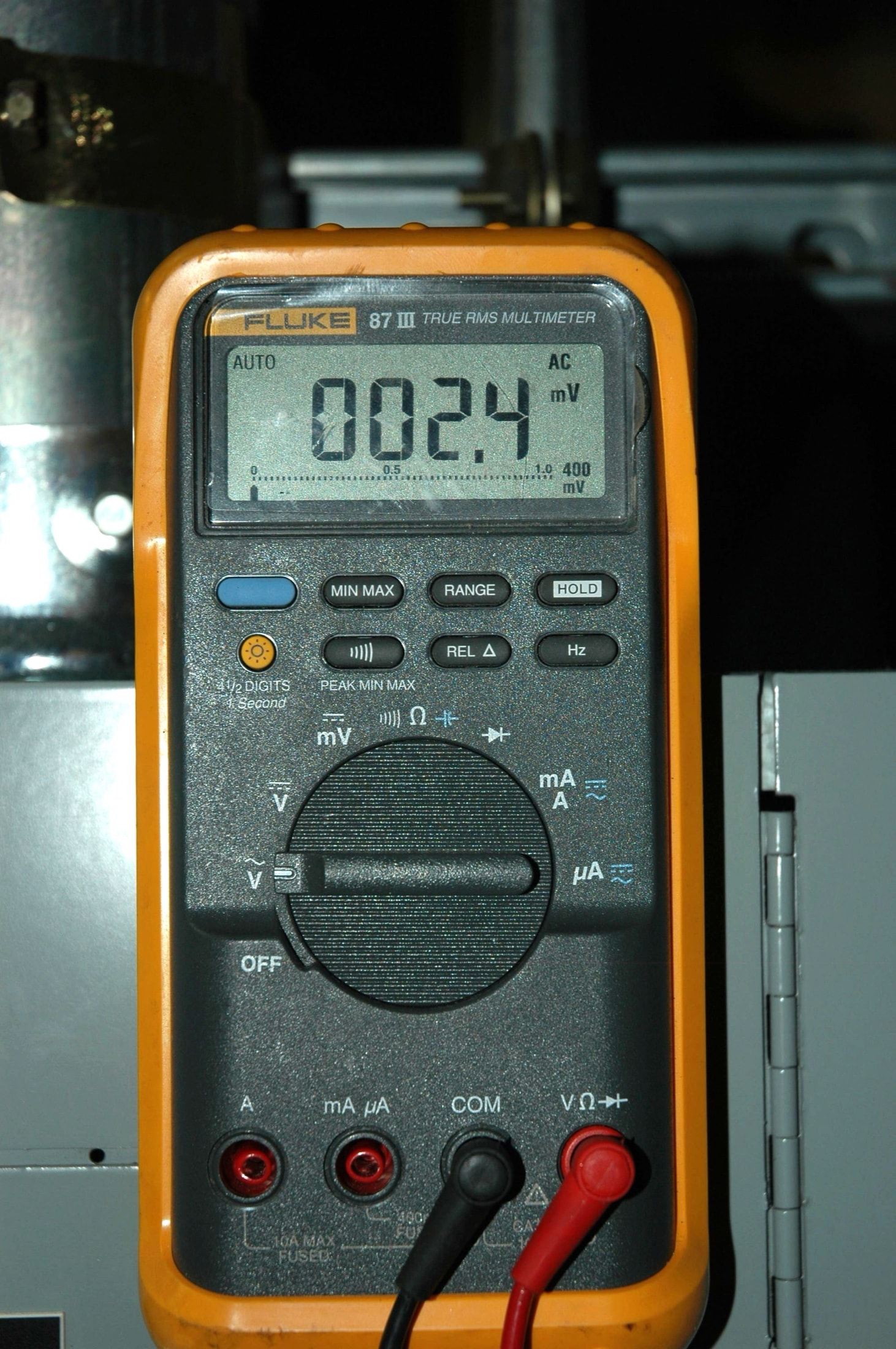 Multimètre numérique Fluke 87 III avec sondes branchées, écran allumé