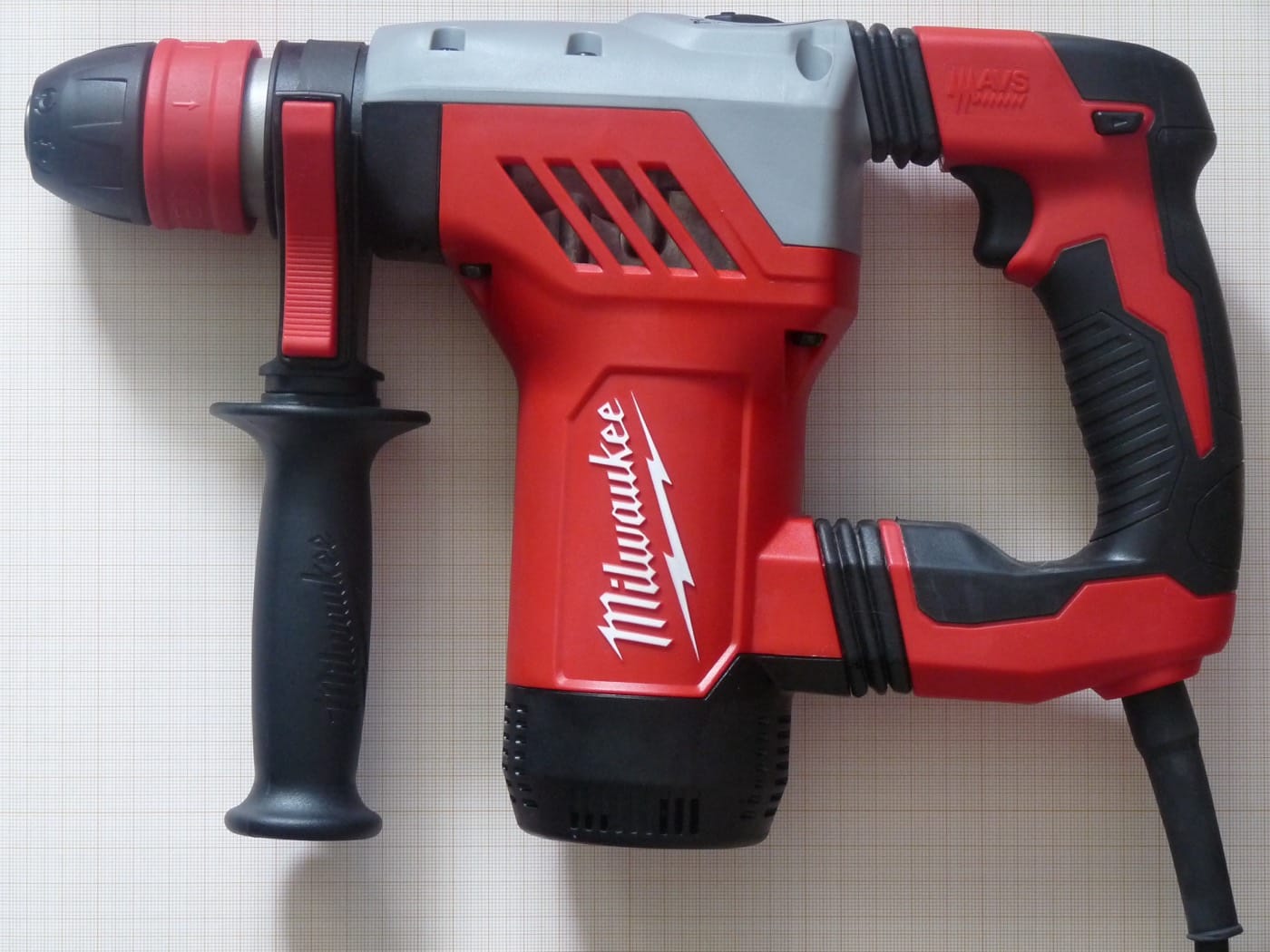 Perforateur Milwaukee SDS posé sur une surface de chantier