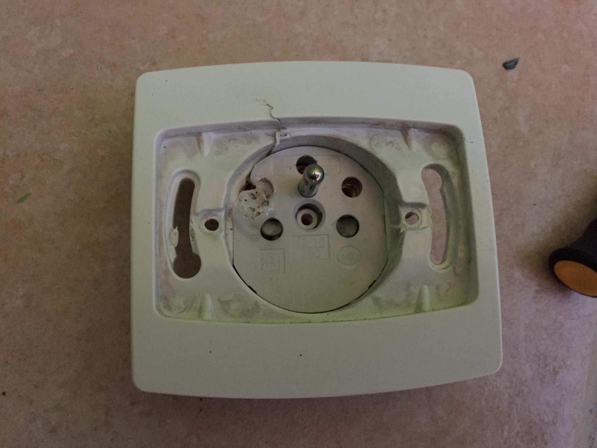Prise électrique murale dont l’alvéole inférieure est brûlée