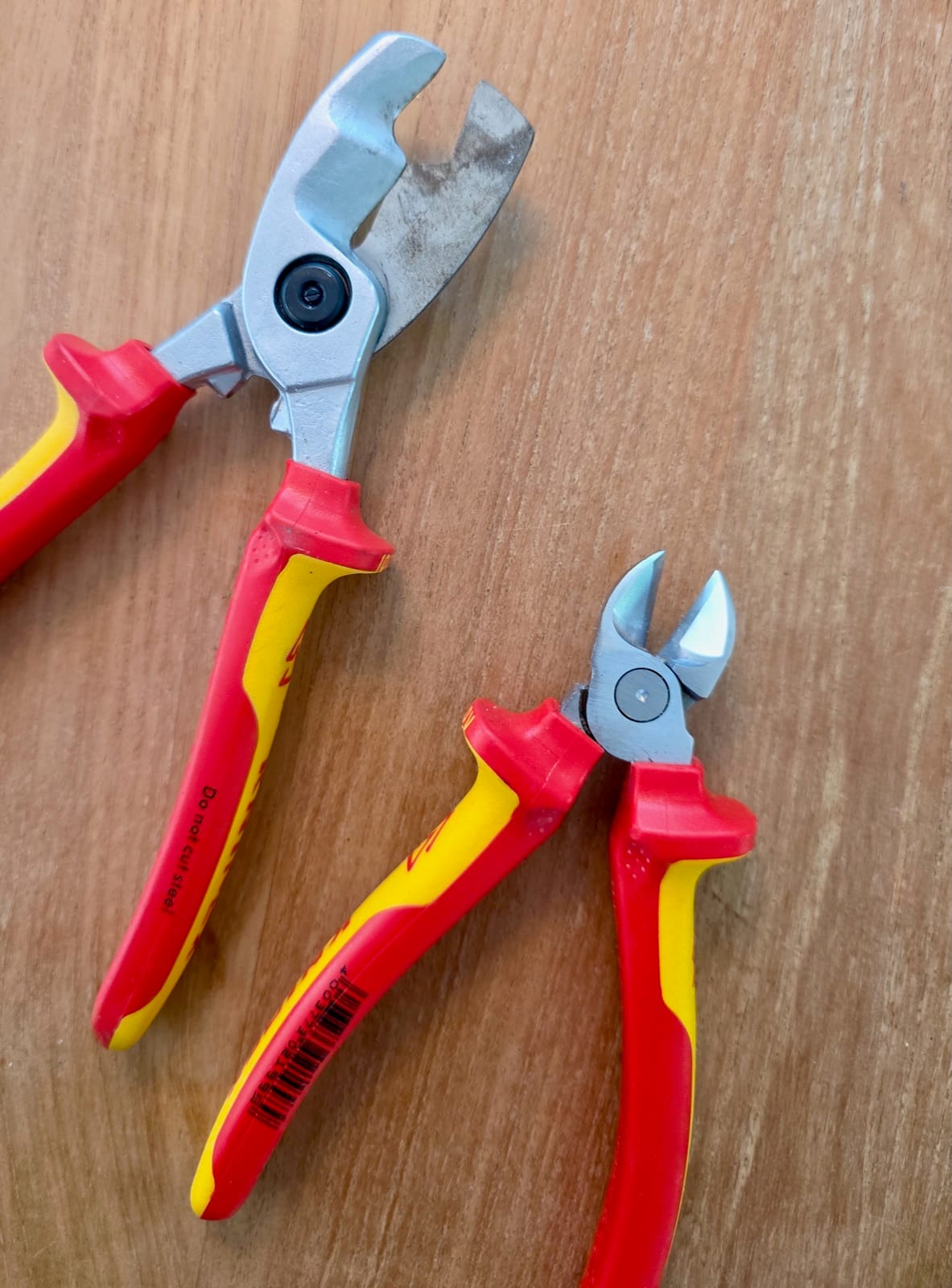 Coupe-câbles et pince coupante Knipex à poignées isolées rouge et jaune montrant deux fonctions différentes