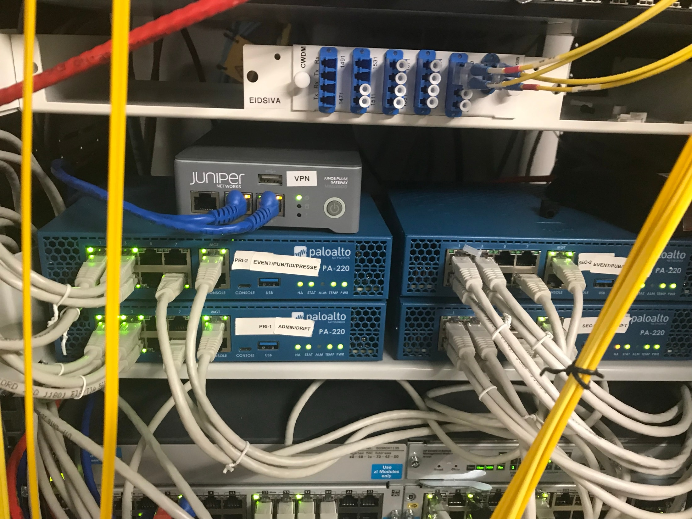 Deux pare-feux Palo Alto Networks PA-220 installés dans une baie avec des équipements Juniper et un câblage Ethernet dense