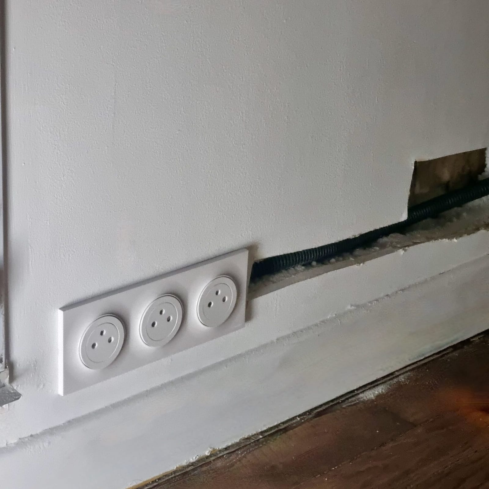 Boîtier de prise électrique installé dans une cloison en placo ouverte