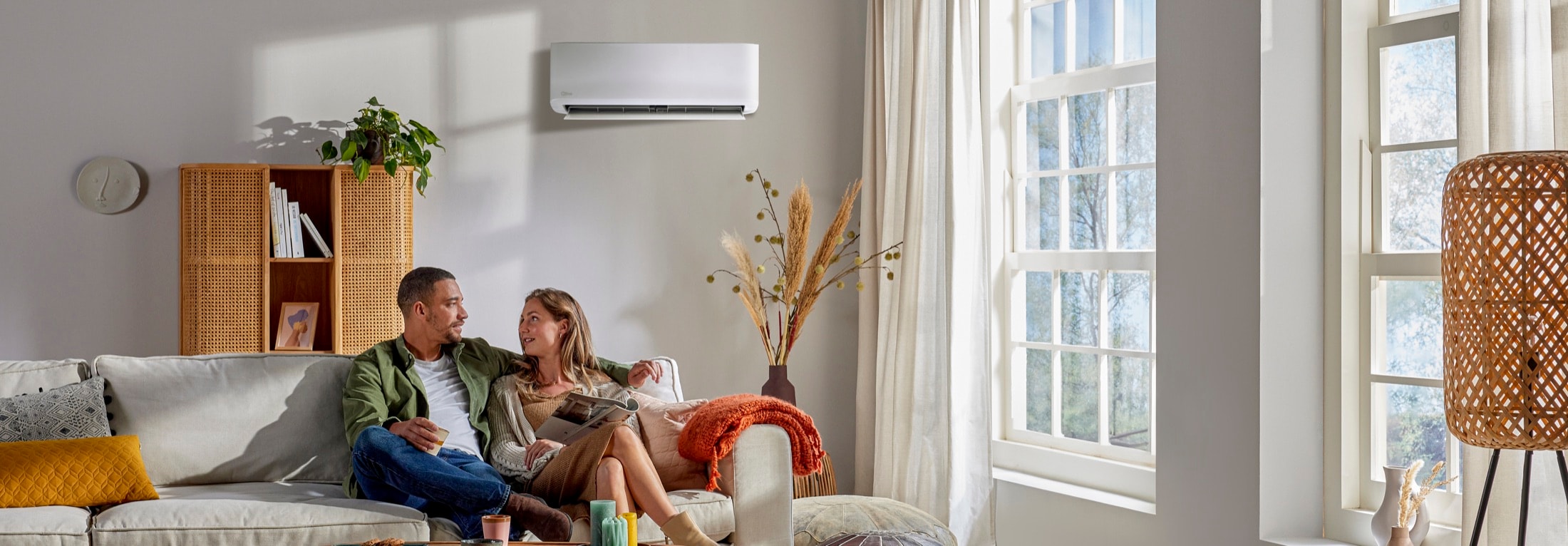 Climatiseur split réversible Qlima SC6026 dans une pièce de vie, unité intérieure au mur