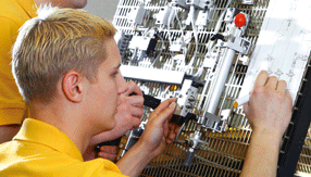 Technicien REMS assemblant une presse de sertissage sur une ligne de production