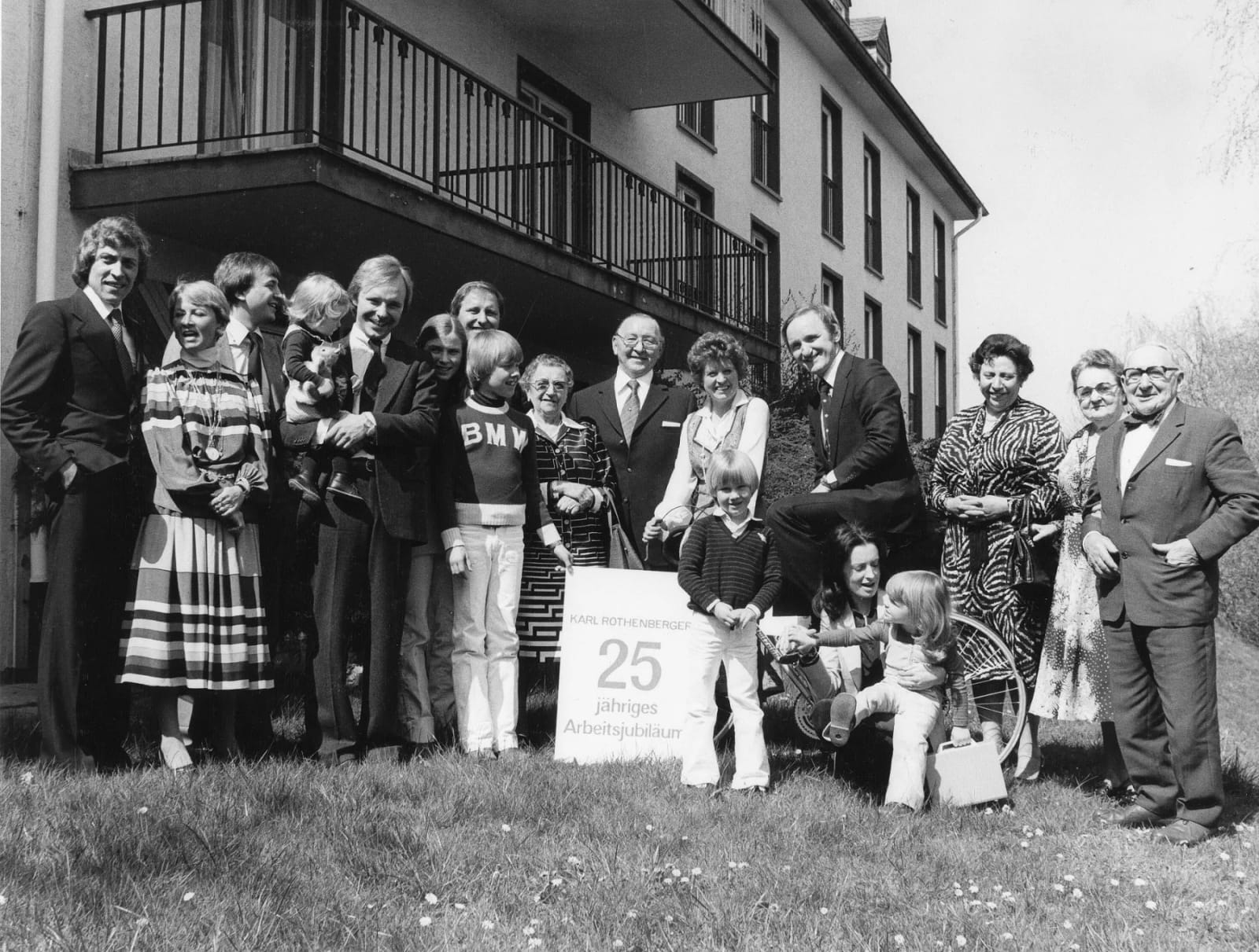Photographie en noir et blanc d'une réunion de plusieurs générations de la famille Rothenberger devant un immeuble, à l'occasion d'un jubilé professionnel
