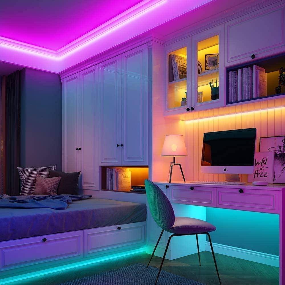 Chambre avec rubans LED colorés installés au plafond et sous les meubles créant un éclairage multicolore