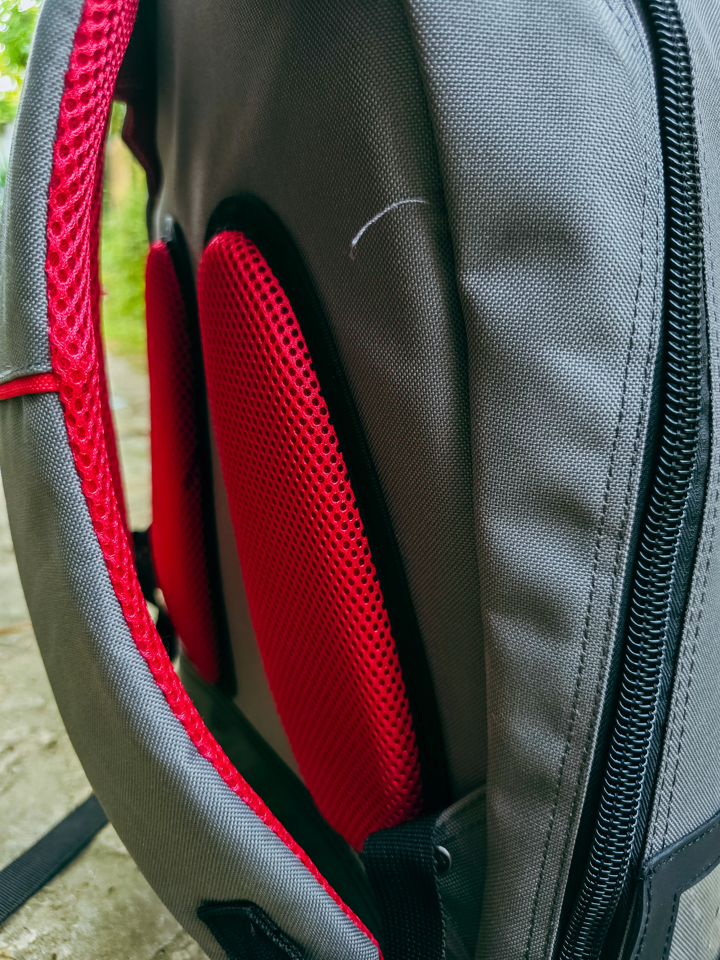 Dos d’un sac C.K Magma gris et rouge avec panneau de tissu maillé