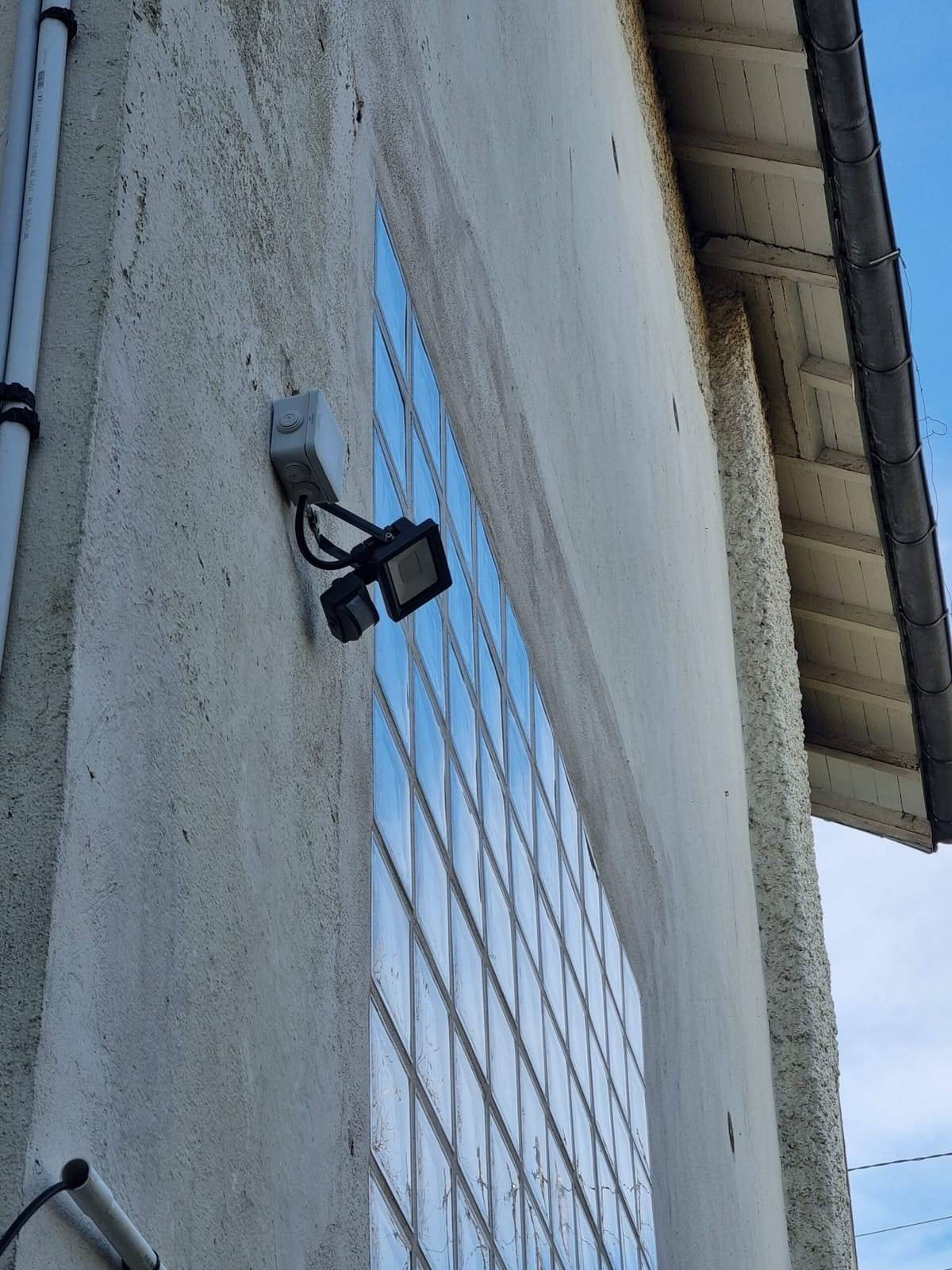 Projecteur avec détecteur de mouvement posé sur façade privée
