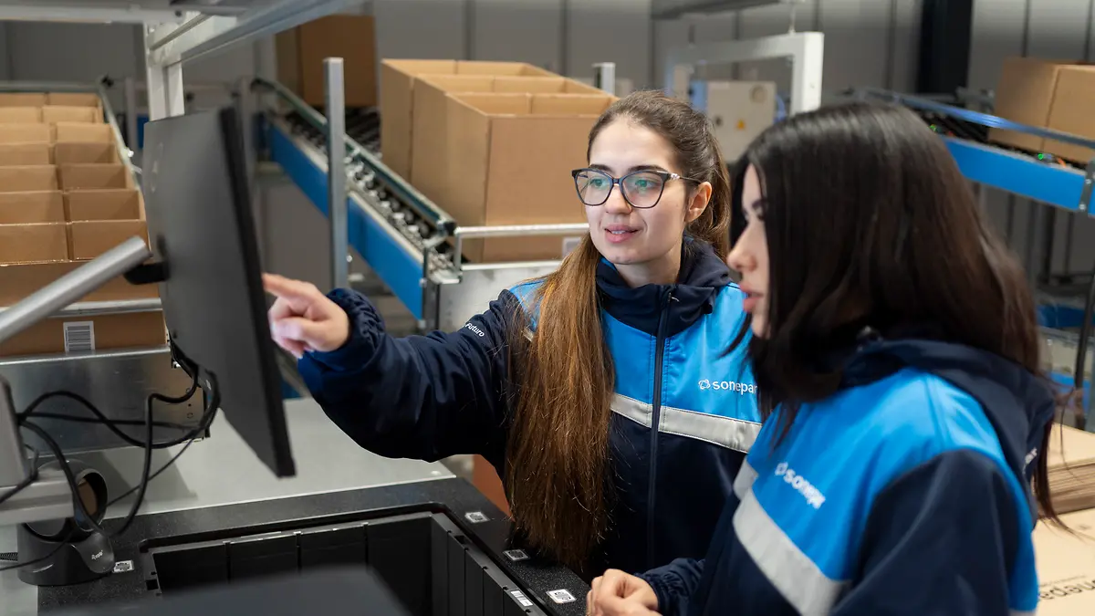 Deux collaboratrices Sonepar devant un poste informatique dans un centre de distribution italien