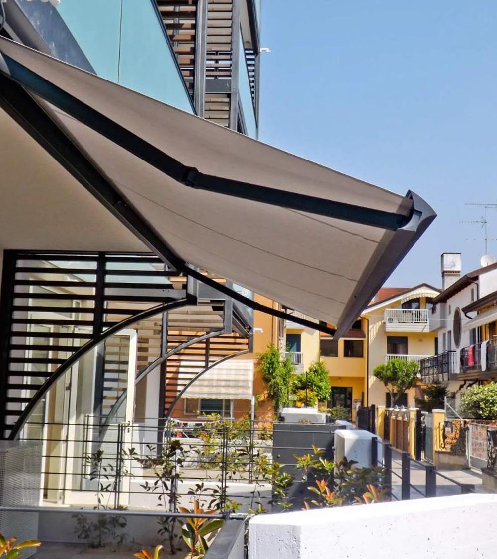 Store banne beige déployé sur une terrasse avec structure noire, devant des bâtiments résidentiels