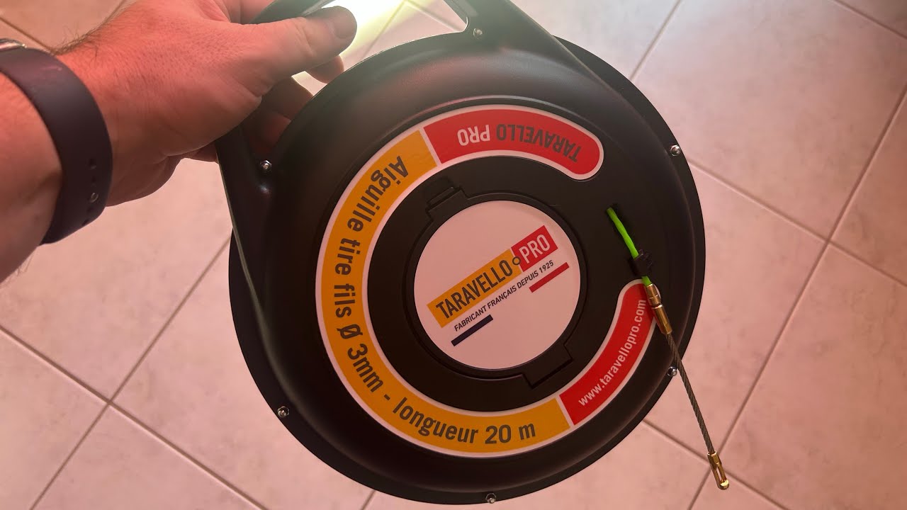 Aiguille tire-fils Taravello Pro tenue par sa poignée, fil déroulé au sol