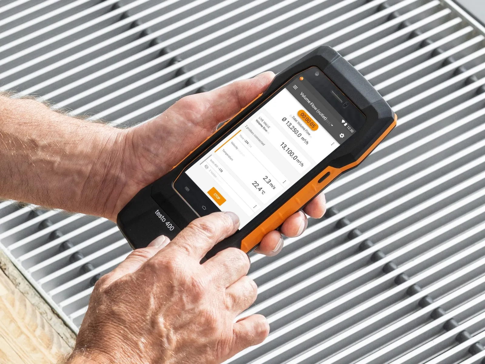 Testo 400 utilisé devant une grille pour relever une mesure de débit d’air