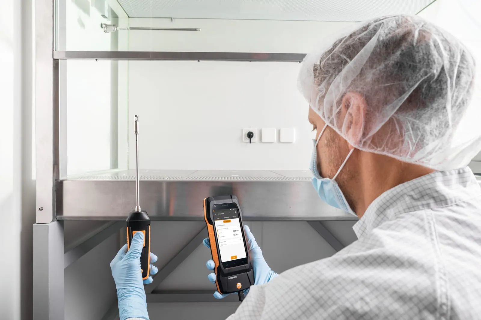 Technicien utilisant une sonde et un appareil Testo 400 pour une mesure d’air en enceinte contrôlée