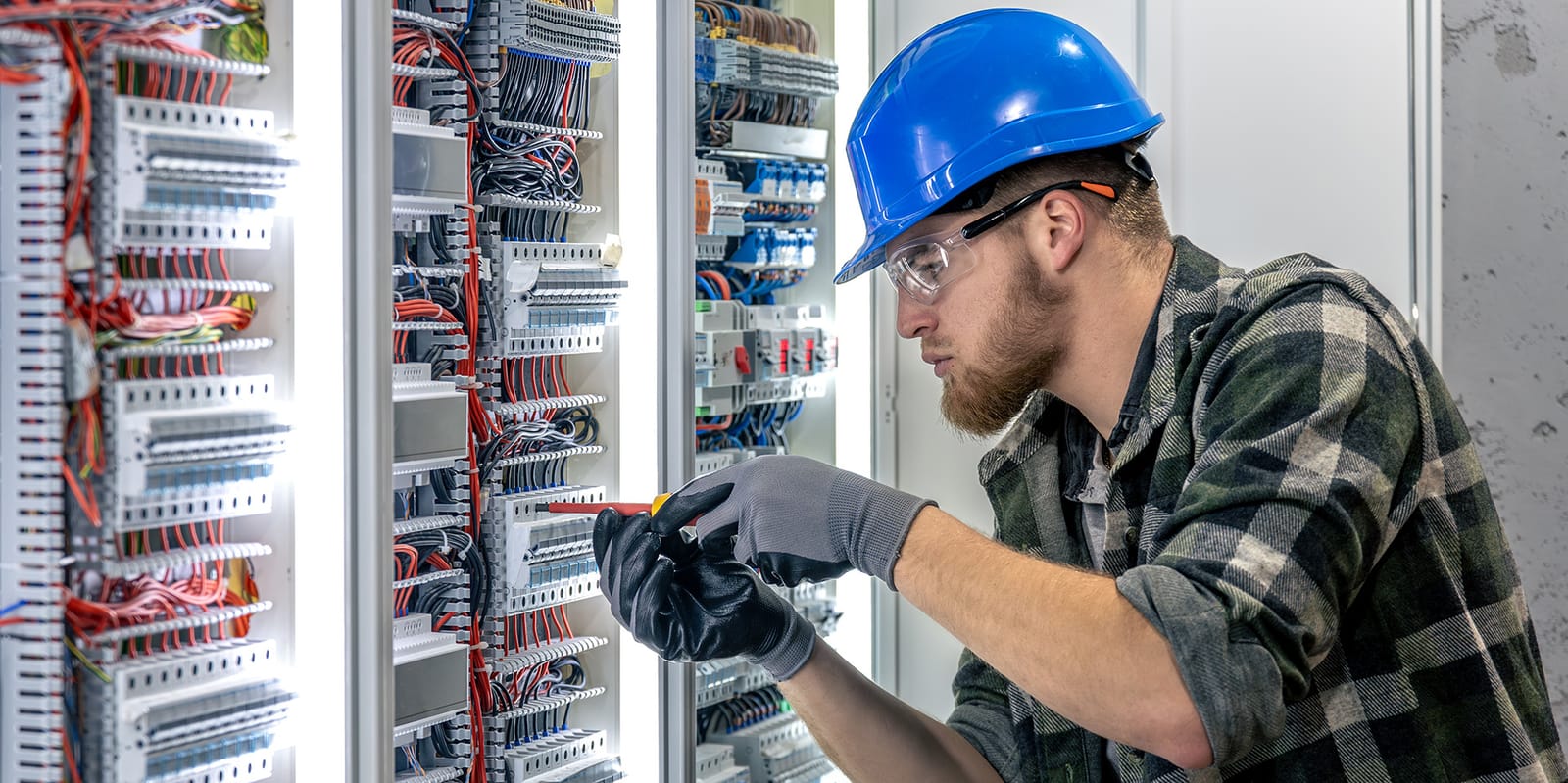 Apprenti électricien intervenant sur un tableau électrique pendant sa formation