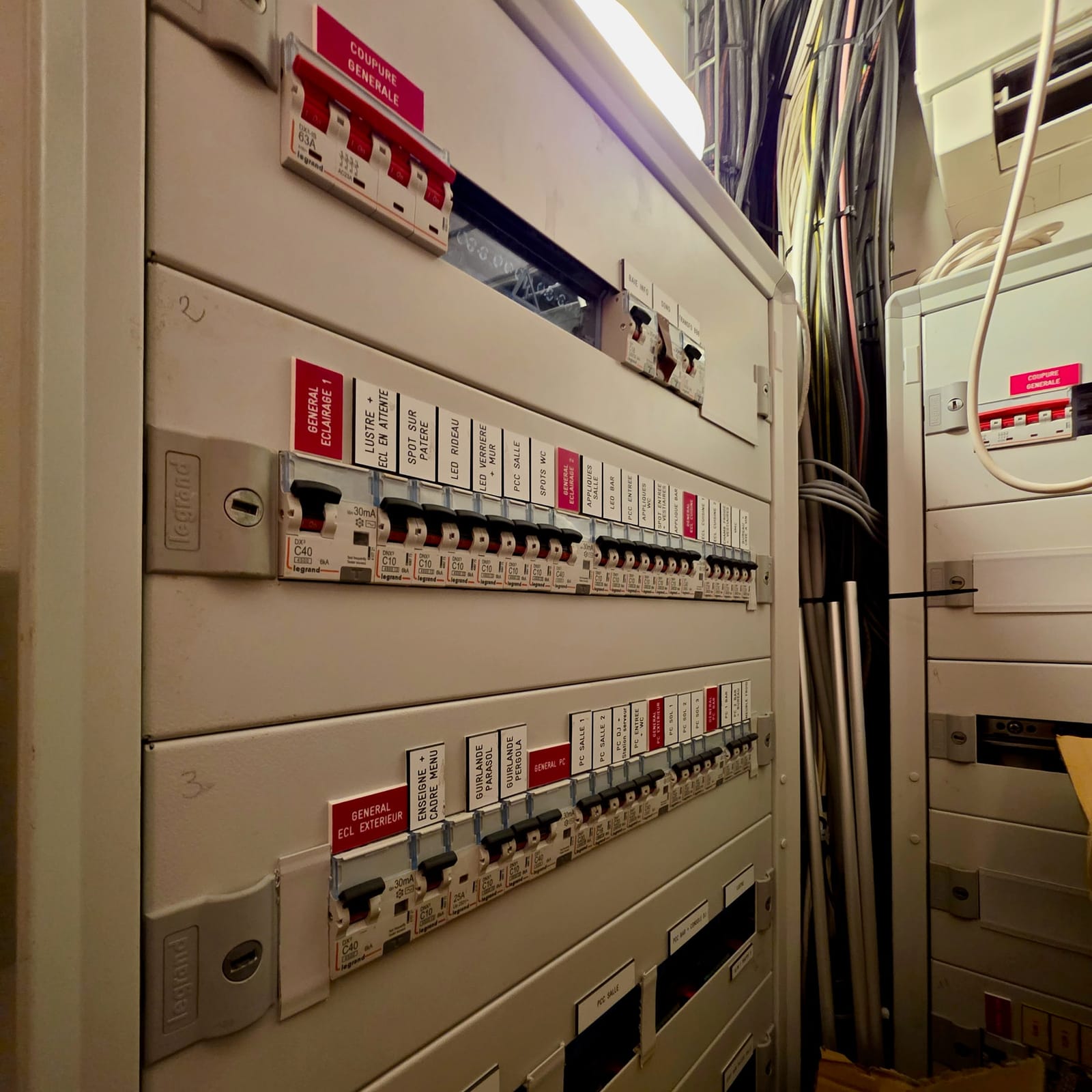 Grand tableau électrique tertiaire étiqueté avec disjoncteurs et repérage des circuits