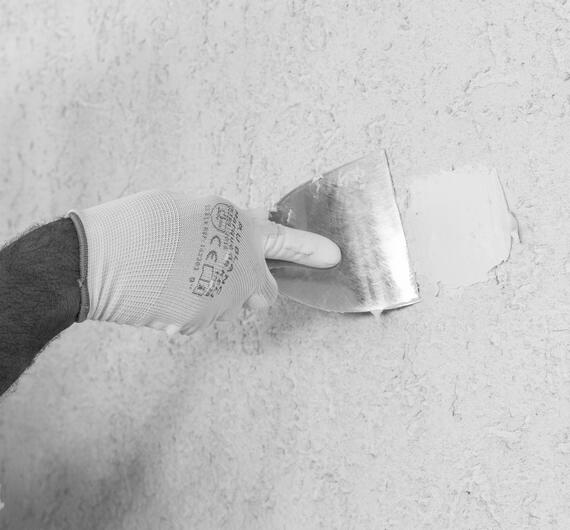 Application d’un enduit de rebouchage au couteau à enduire sur un mur