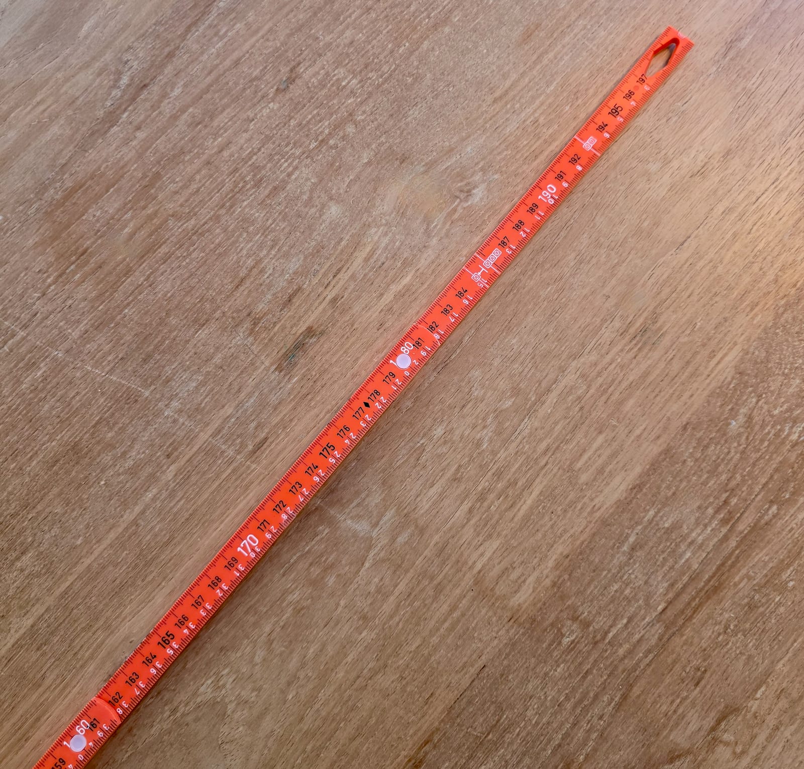 Mètre pliant Wiha Longlife electric rouge et jaune posé ouvert sur une table