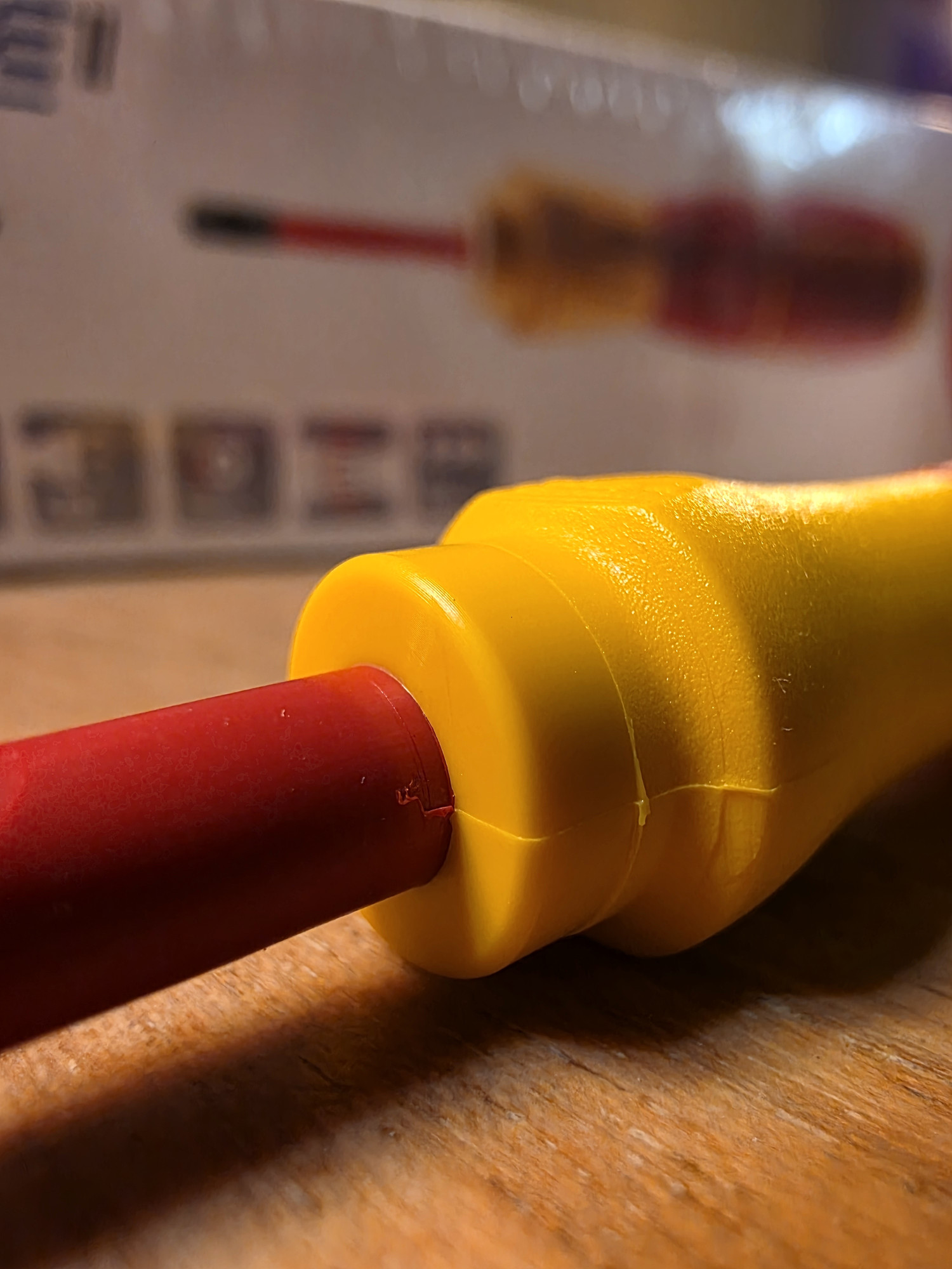Jonction visible d’une gaine rouge avec le manchon jaune d’un outil Wiha