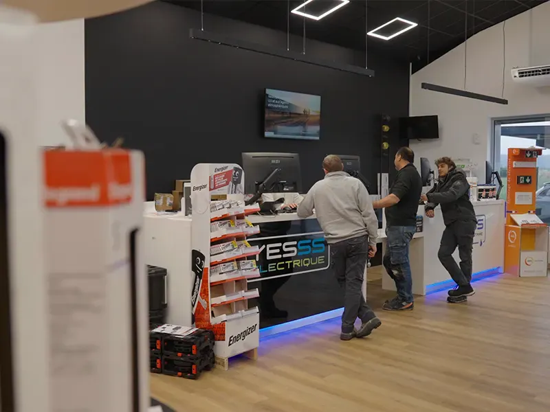 Intérieur d’une agence YESSS Électrique avec rayonnages et comptoir