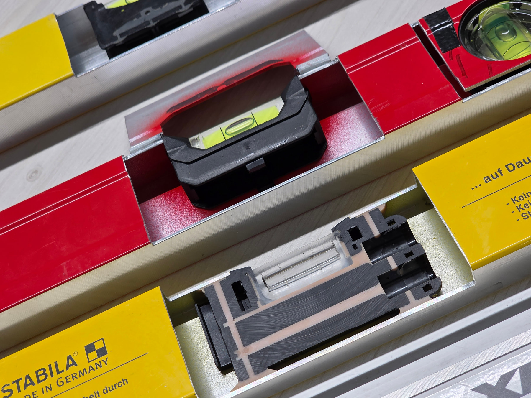 Coupe transversale d'un niveau STABILA montrant la fiole scellée dans la résine époxy du profilé aluminium