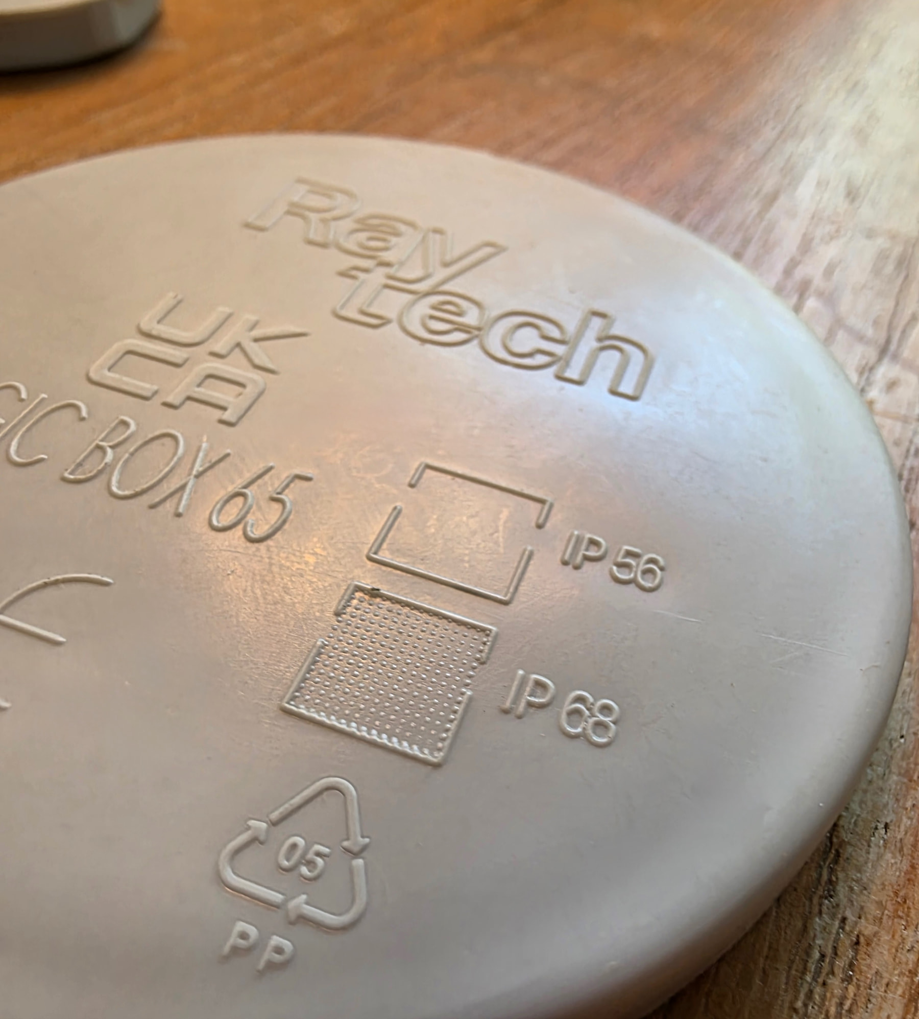 Couvercle blanc d’une boîte de dérivation étanche Raytech Magic Box 65, gravures IP56 et IP68 et logo de la marque