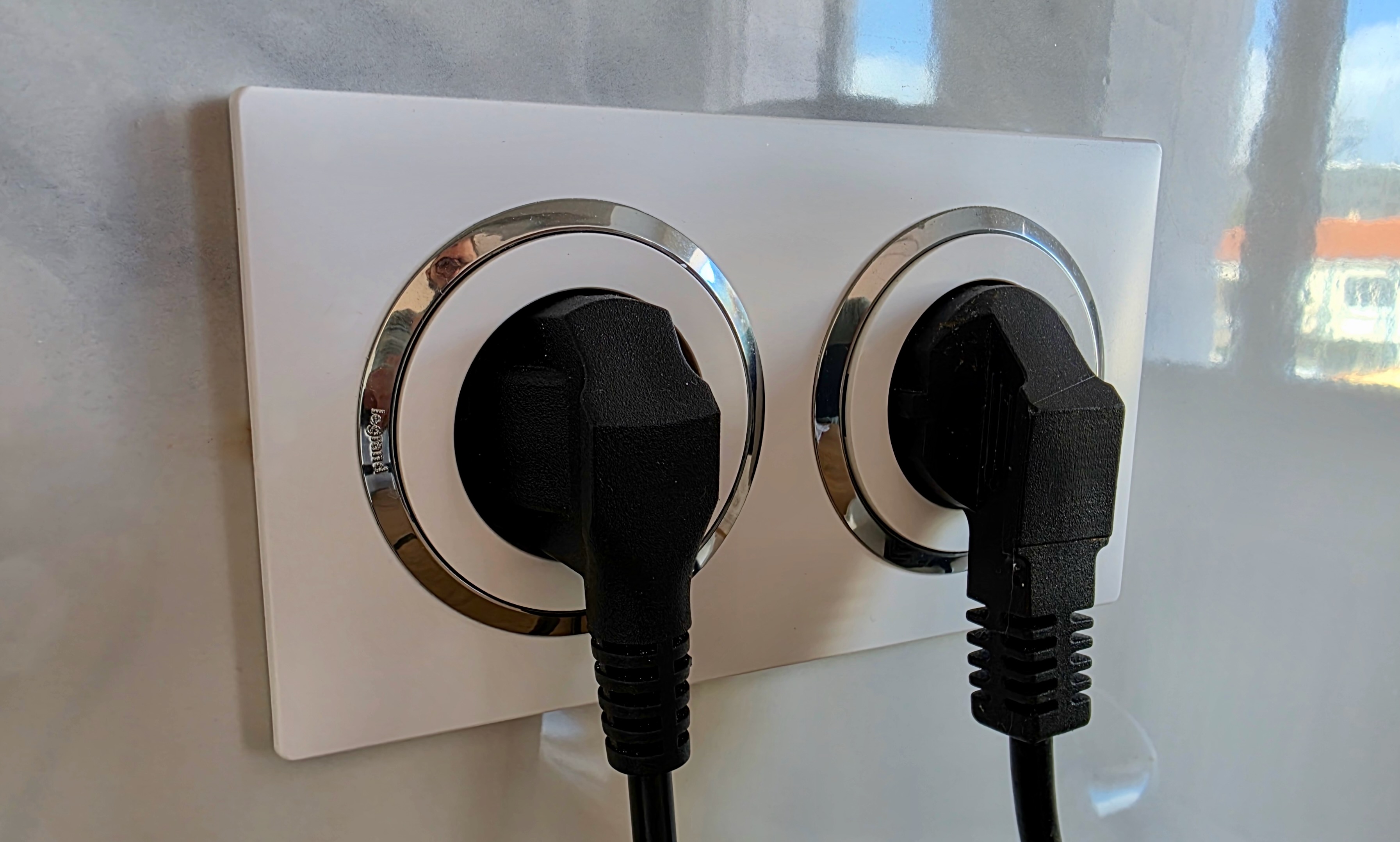 Double prise Legrand Dooxie avec bague effet chrome et appareils branchés