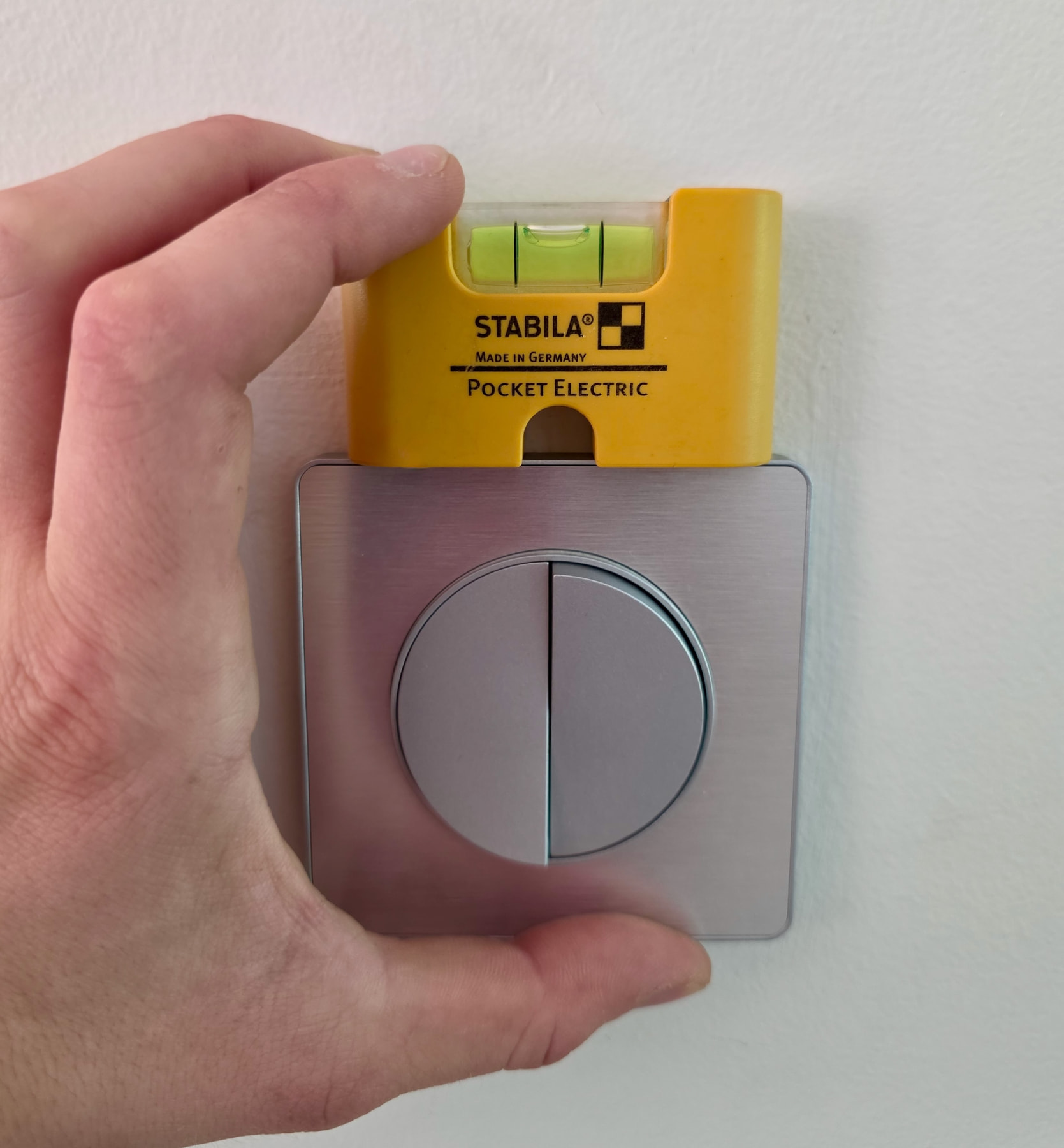 Mini-niveau Stabila magnétique posé sur une prise pour la mettre de niveau
