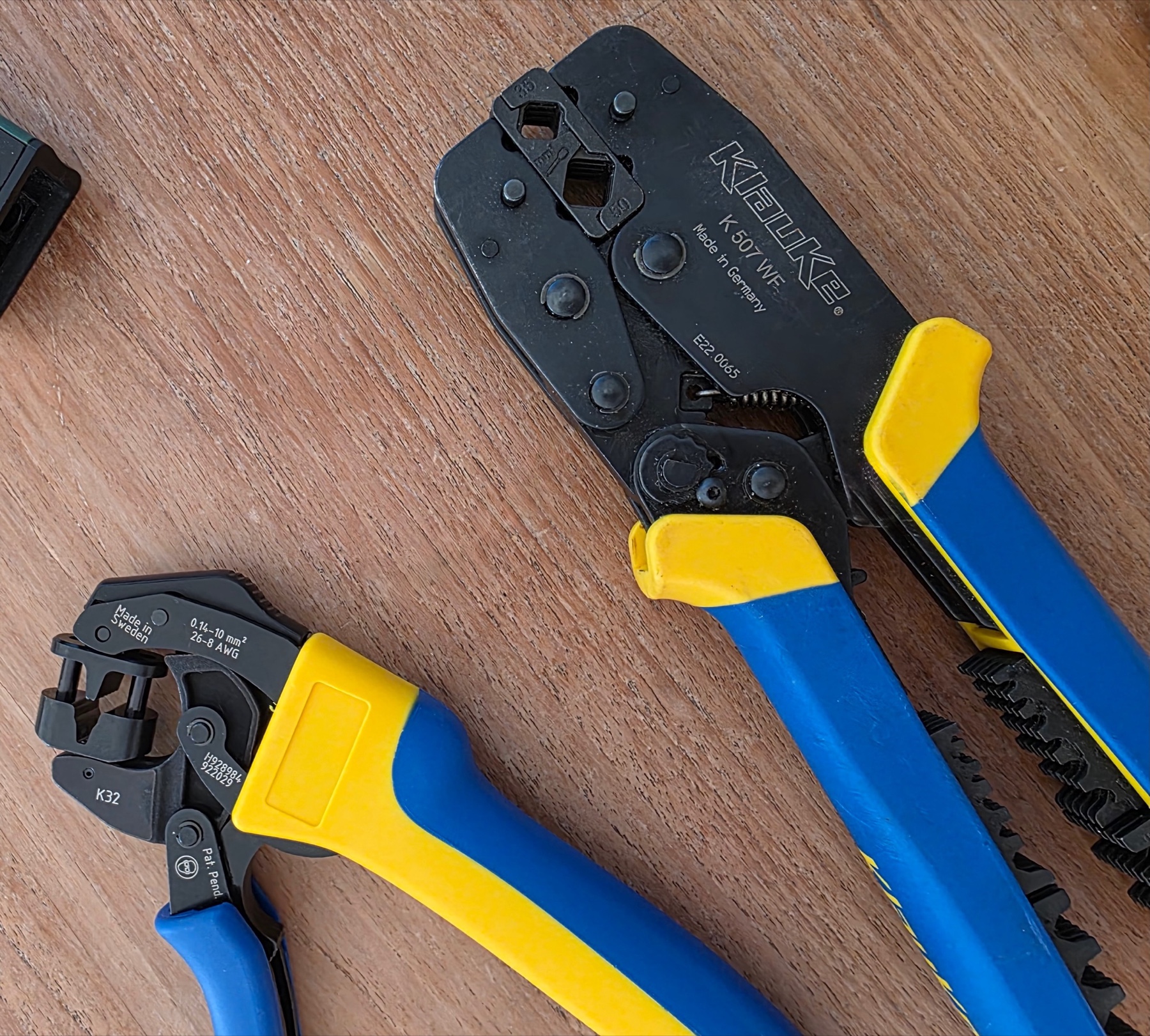 Pinces à sertir Klauke K 507 WF et K32 posées côte à côte sur un établi en bois